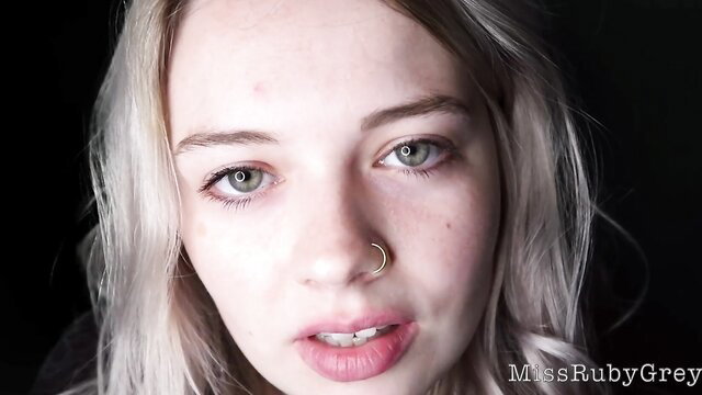Miss Ruby Grey closeup portrait, blonde hair green eyes nose piercing