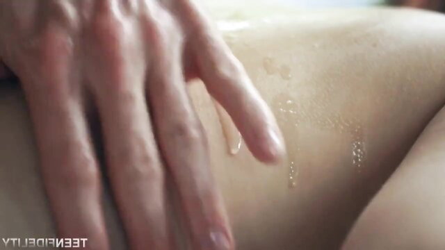 Erotic oil massage on nude woman's back and ass closeup