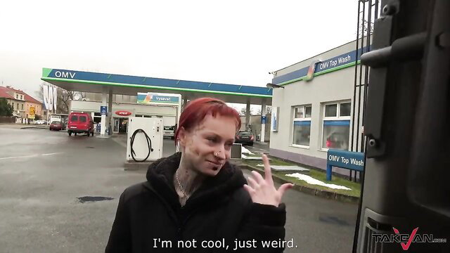 Redhead pierced tattooed goth babe smiles at gas station, weird vibe