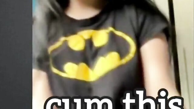 Asian girl in tight Batman shirt lifts to tease tits, cum tribute text