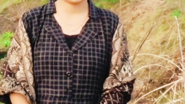 Bengali beautiful girl in checkered shirt and embroidered sleeves outdoors