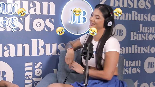 Salome Gil laughing on Juan Bustos Podcast in white top and blue skirt