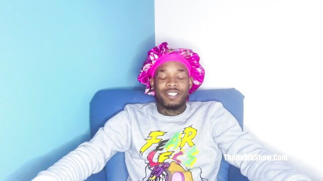 Black man in pink bonnet and Fear sweatshirt chilling seductively