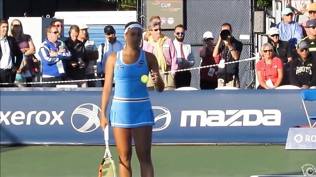 Hot black tennis player in blue skirt dress holding racquet on court