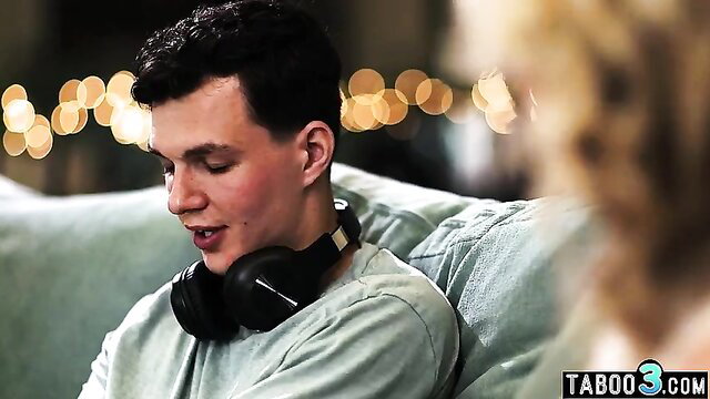 MILF teases stepson with headphones on couch closeup