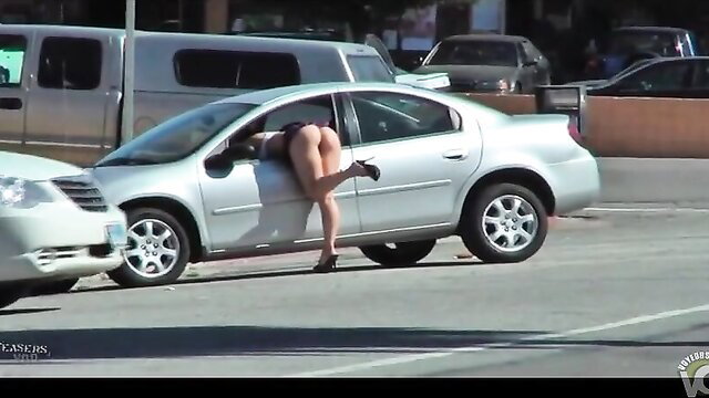 Raven-haired bombshell in tiny skirt flashes huge ass from car door
