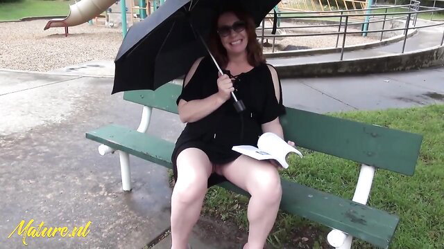 Redhead cougar Marelli reads book braless no panties on park bench