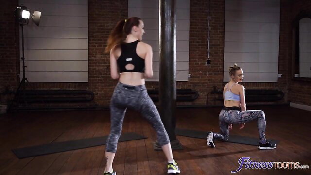 Fit redhead and blonde in leggings twerking at pole gym