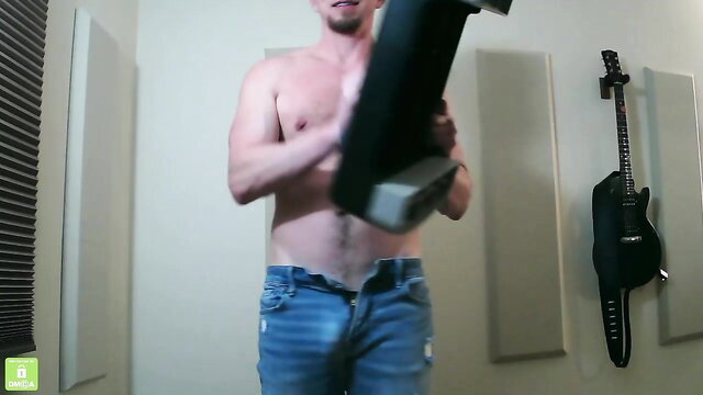 Shirtless hairy-chested Swedish guy holds black toy in ripped jeans