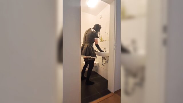 Caged sissy maid serf in latex skirt washes hands in bathroom