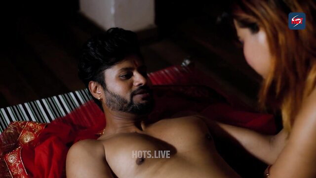 Man and woman in bed, man shirtless with red fabric around him