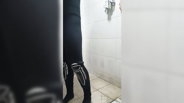 Closeup of shiny black scuba boots and shinguards on toned legs in steamy shower