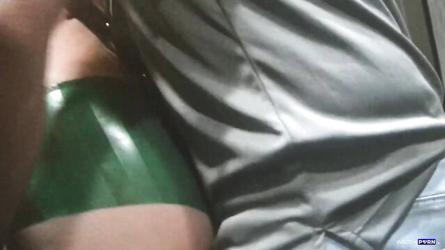 Helenas Cock Quest in green latex arm and satin blouse closeup
