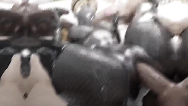 Hand holding a dark brown artificial penis