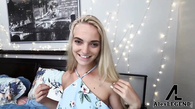 Blonde Alex Legend in floral dress holds panties, smiling seductively