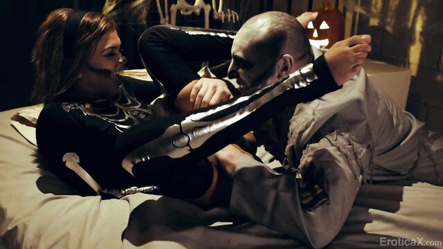 Destiny Cruz in latex catsuit wrestles hot zombie BF on bed