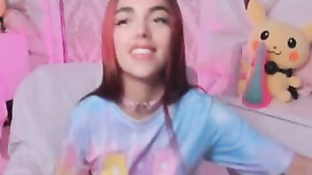 Redhead tattooed cam girl smiles in Pikachu room, tie dye tee