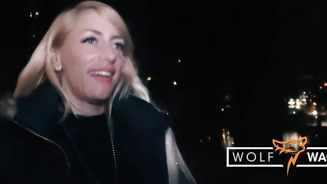 Blonde Wolf Wagner in sexy coat, wet night outdoor tease