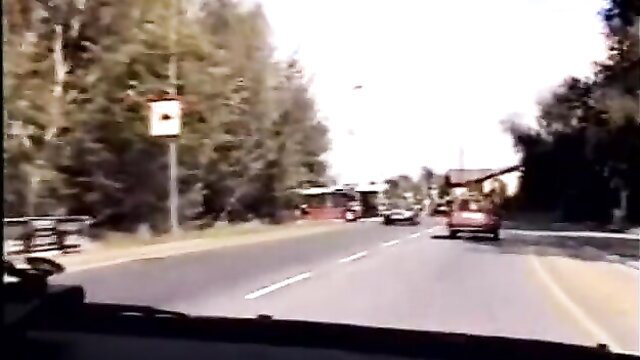 Outdoor road scene with red vehicles and trees, human punching bag video thumbnail