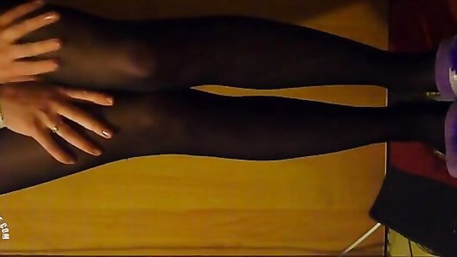 Skinny girl hands on black pantyhose legs in sexy pose