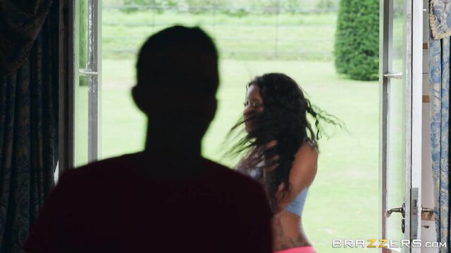 Ebony babe in skimpy bikini outdoors with shadowy man watching