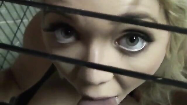Blonde amateur with tongue out peeking through cage bars