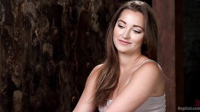 Dani Daniels smiling in tank top, brutal bondage preview