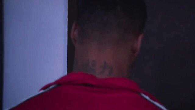 Black man with neck tattoo turns back in red Adidas jacket, BBC intern tease