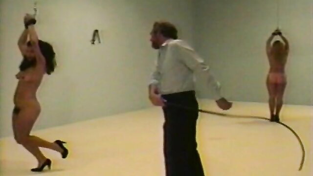 Nude women whipped and suspended in BDSM dungeon scene