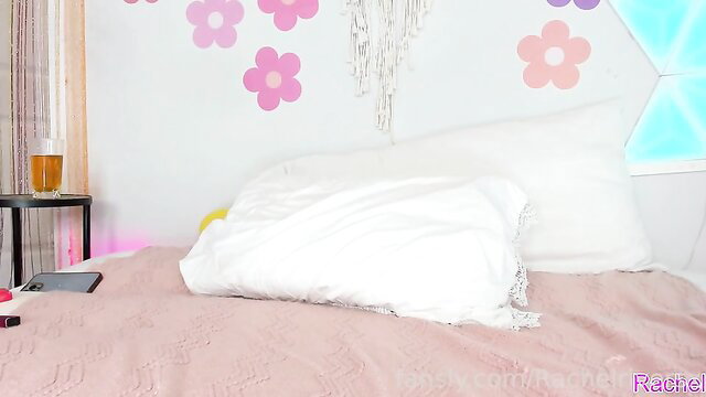 Rachel Rivers topless on bed in pink room, seductive pose