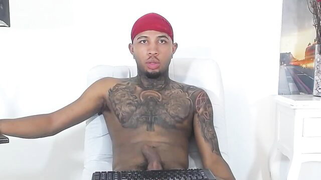 Tattooed black guy solo exposing huge cock on webcam