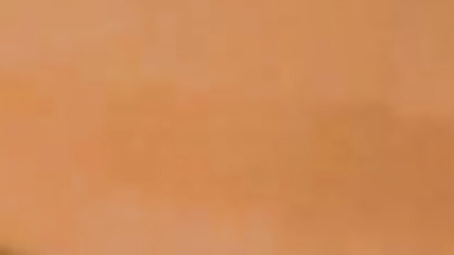 Blurry orange-tinted adult video thumbnail, no explicit details visible