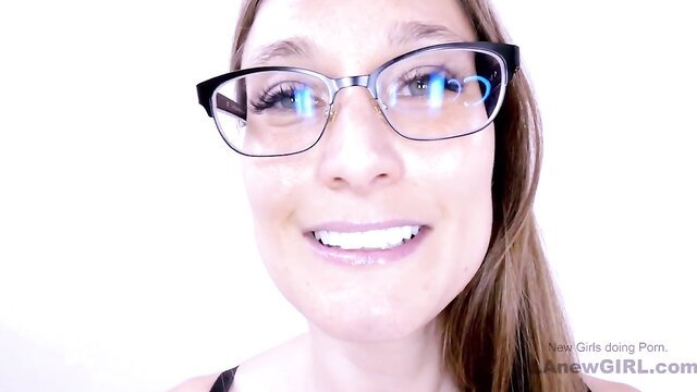 Smiling brunette beauty in glasses poses topless for porn