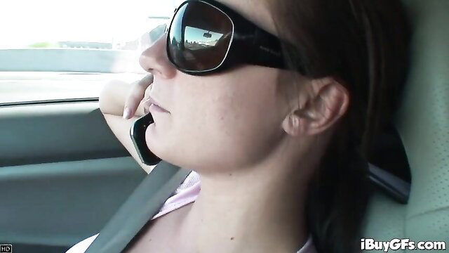 Brunette in car wearing big sunglasses talks on phone, teasing blowjob vibe