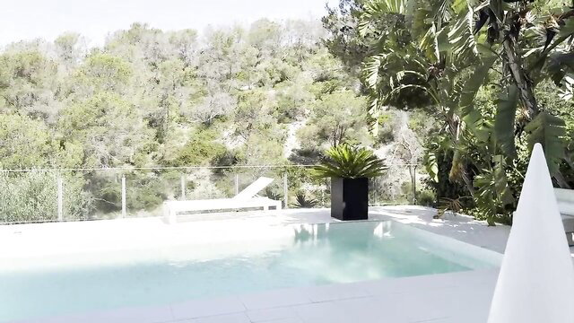 Relaxing by the pool surrounded by lush greenery