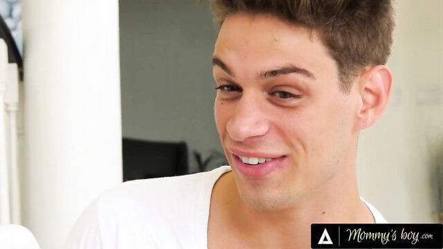 Handsome young mommy's boy smirking in tight white tank top