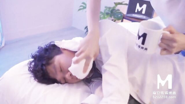 Asian man in white shirt cared for by hand holding mug on bed, JAV thumbnail