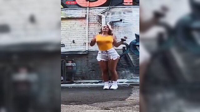 Hot blonde shuffle dancer in tight yellow top and denim shorts twerking outdoors