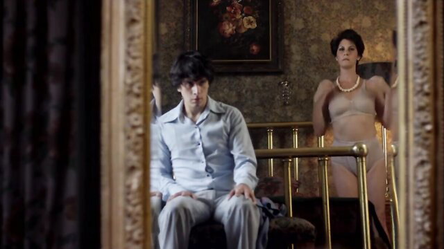 Brunette MILF in lingerie watches young man in mirror voyeur scene