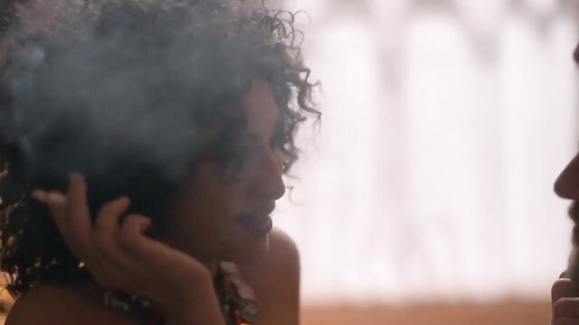 Curly-haired black woman smoking intimately close-up in Curiosa 2019