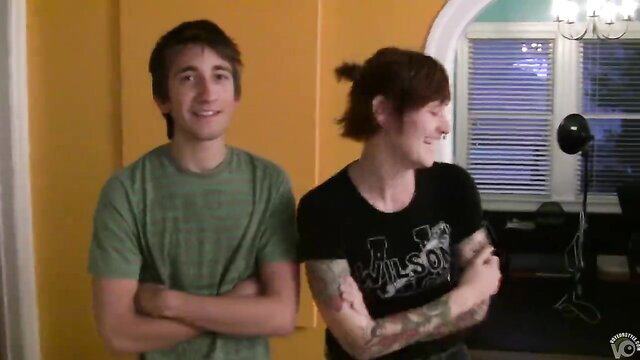 Tattooed emo GF in black Wilson tee and jeans smiles with boyfriend