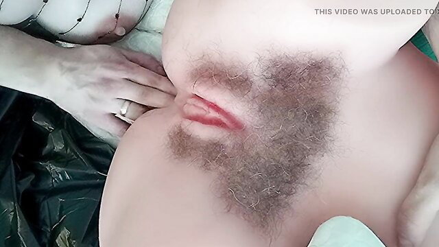 Closeup of hairy pussy with woman's hand spreading lips in HD Monique video