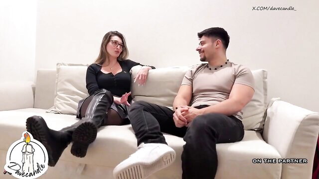 Brunette in black top and thigh-high boots handjobs muscled guy on couch