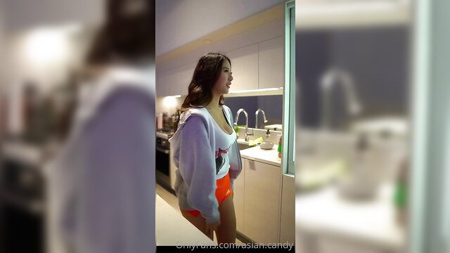 Asian waitress Candy in orange hotpants and crop top offers her pussy