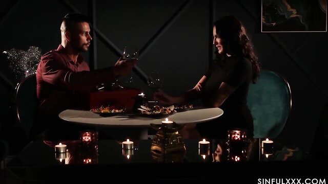 Hot Latino couple toasting wine at intimate candlelit dinner date