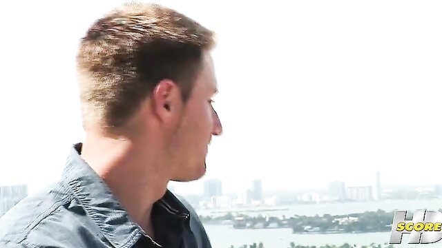 Blond man profile view overlooking Miami skyline in adult video thumbnail