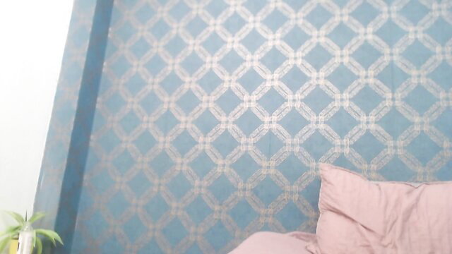 Violeta_cute18 on bed with pink pillow, teal lattice wall