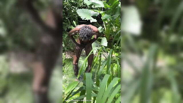 Nude big-dicked Jamaican man bathing outdoors in jungle, muscular ass view