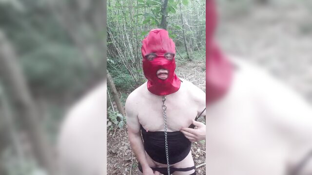 Fabienne sissy in red hood, harness, chains in woods outdoor kink