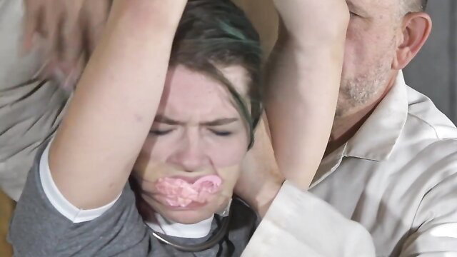 FutileStruggles: Green-haired brat gagged with pink ballgag, arms pinned by older man